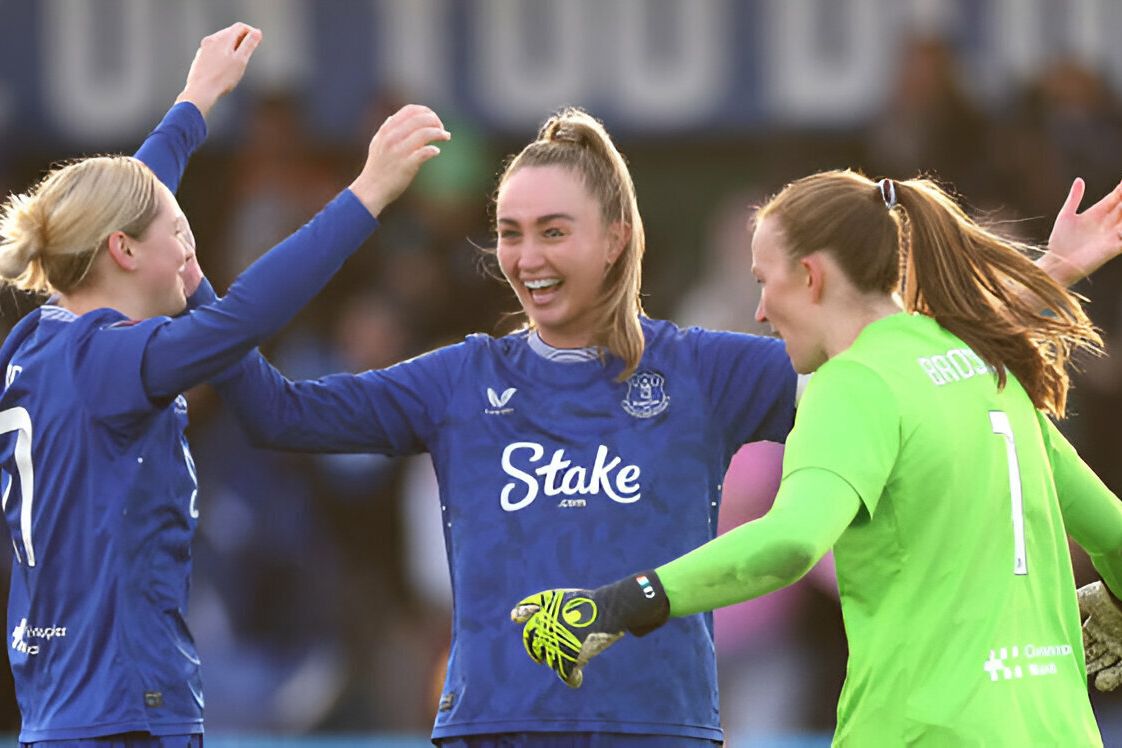 Megan Finnigan of Everton celebrates victory with teammates Lucy Hope and Courtney Brosnan after the Barclays Women's Super League match between Everton and Manchester City at Walton Hall Park on December 15, 2024 in Liverpool, England.